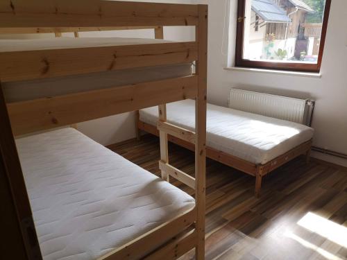 2 łóżka piętrowe w pokoju z oknem w obiekcie Sobe SM0LEJ w Bledzie
