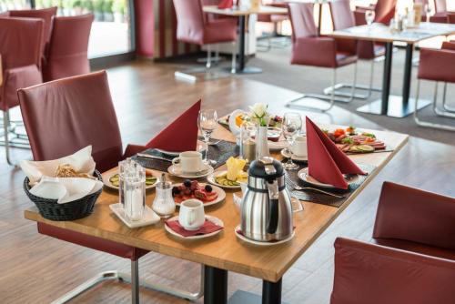 a table with plates of food on it in a restaurant at Hotel & Golfrestaurant Gut Wissmannshof in Staufenberg