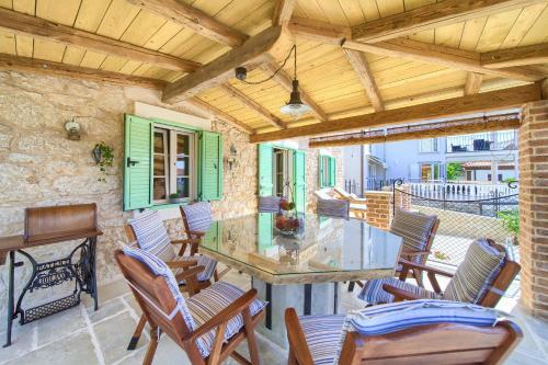 a patio with chairs and a glass table on a patio at Villa Stone Queen in Malinska