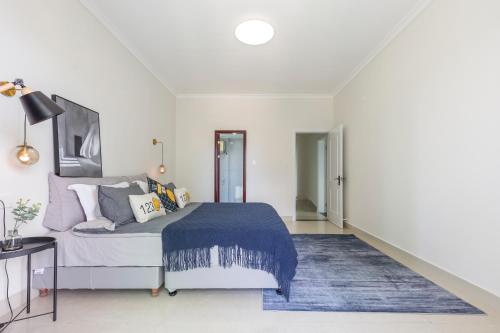 a bedroom with a bed and a blue rug at Sanya Sun Seaview Apartment in Sanya