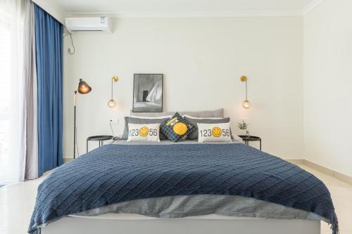 a bedroom with a bed with a blue comforter at Sanya Sun Seaview Apartment in Sanya