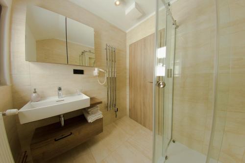 a bathroom with a sink and a shower at Hotel Praha in Špindlerův Mlýn