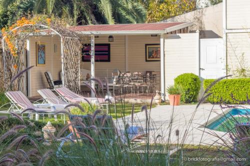 a patio with chairs and a table in a yard at Delvino Boutique Hotel in Salta