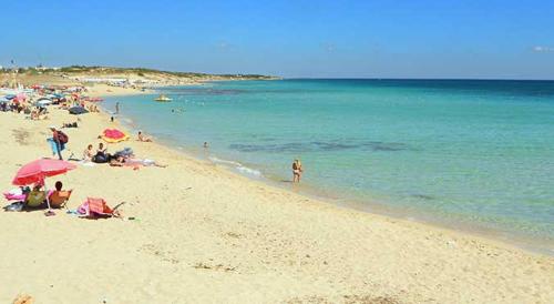 a group of people on a beach with the ocean at B&B Lo Scrigno del Salento in Sava