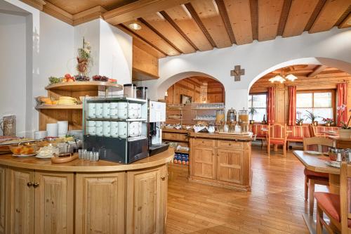 a large kitchen with wooden cabinets and a dining room at Hotel Alpenhof - New Sauna Area in Bad Hofgastein