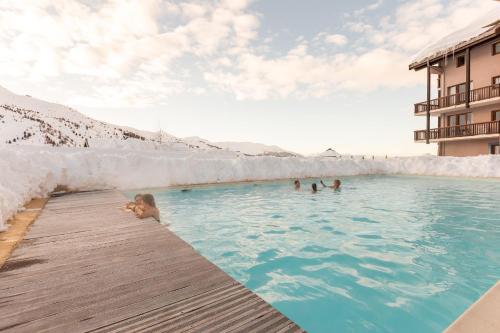 un groupe de personnes dans une piscine dans l'établissement Residence Le Thabor - maeva Home, à Valmeinier