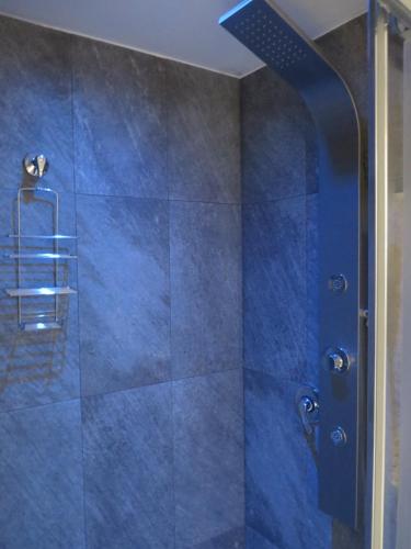 a bathroom with a shower with blue tiles at la Postierla in Modica