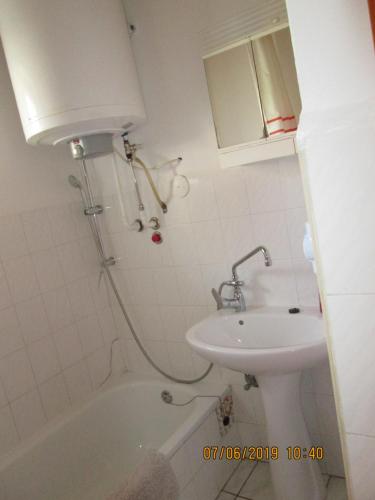 ein Badezimmer mit einem Waschbecken, einer Badewanne und einem WC in der Unterkunft Fenyves Vendégház in Balatonfenyves