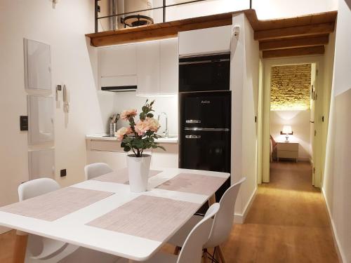 cocina con mesa blanca y sillas blancas en Apartamentos Granada Deluxe 3000, en Granada