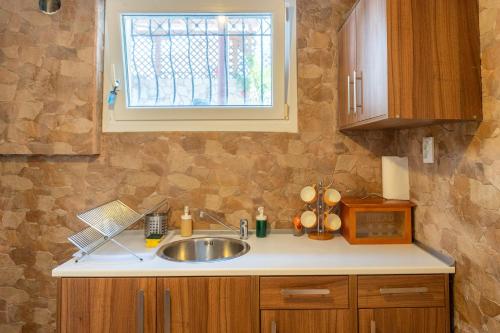 a kitchen counter with a sink and a window at Starfish Villa in Iraklitsa