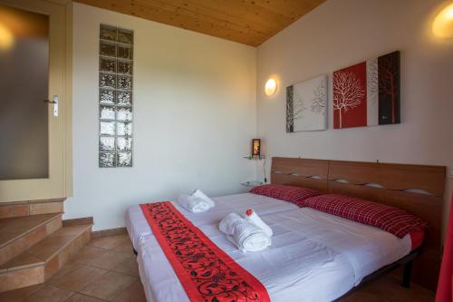 - une chambre avec un lit doté d'oreillers rouges et blancs dans l'établissement Garda Hills Residence, à Roe