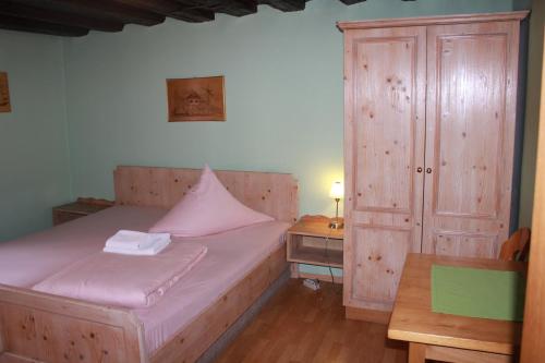 1 dormitorio con 1 cama y armario de madera en Hotel Zur Friedenslinde, en Núremberg