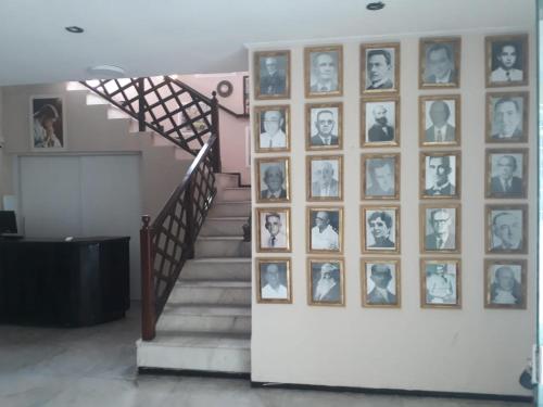 a staircase with a bunch of pictures on a wall at Hotel Nacional in Sobral