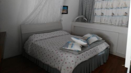 a small bedroom with a bed with pillows on it at a casa di Marzia in Reggio Emilia