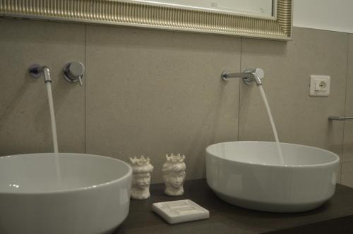 two white sinks in a bathroom with a mirror at BeB L'ALLORO in Pachino