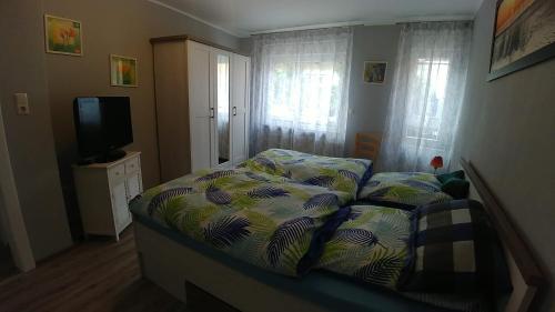a small bedroom with a bed and a television at Ferienwohnung Hansen-Jöns in Friedrichstadt