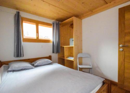 ein kleines Schlafzimmer mit einem Bett und einem Fenster in der Unterkunft Elin 2 in Bagnes