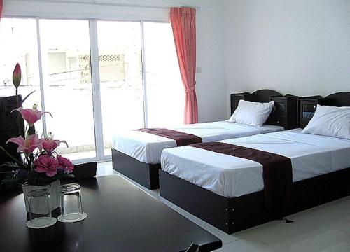 a hotel room with two beds and two lamps at Jomtien Hostel in Jomtien Beach