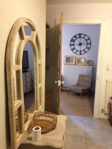 a hallway with a mirror and a clock on the wall at Maison & Tartine in Colombey-les-deux-Églises