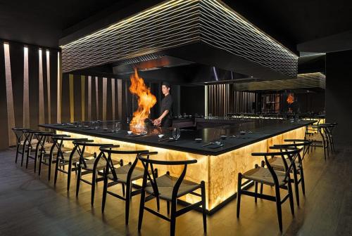 a kitchen with a bar with a bunch of chairs at H10 Costa Adeje Palace in Adeje