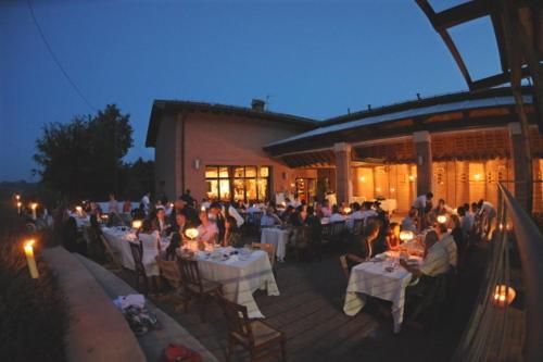 un grupo de personas sentadas en mesas en un restaurante en Agriturismo Il Poggiolo, en Pianoro