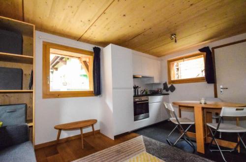 a small room with a table and a kitchen at Elin 2 in Bagnes
