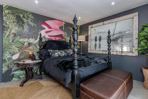 a bedroom with a bed and a wall with a mural at The Hideaway in Benoni