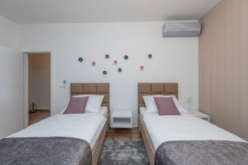 two beds in a room with white and purple at LUXURY APARTMENTS - LA VIR 1 & 2 in Vir