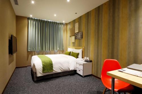 a hotel room with a bed and a desk and chair at ARK Hotel - Dongmen in Taipei