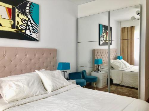 Schlafzimmer mit einem weißen Bett und einem Spiegel in der Unterkunft ALMA Elegant Suite Apartment in Candelaria