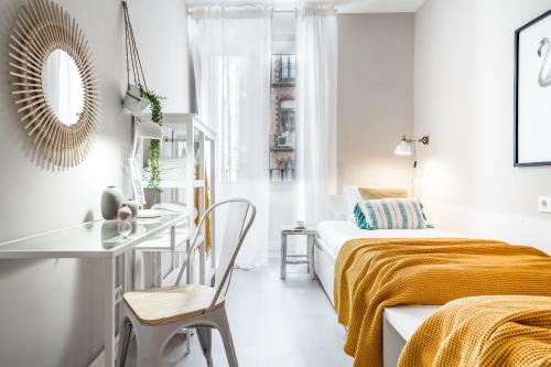 ein weißes Schlafzimmer mit einem Bett und einem Schreibtisch in der Unterkunft Anamar in Pamplona