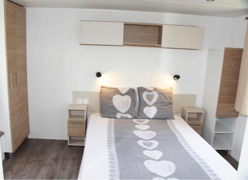 Un dormitorio con una cama con corazones. en Mobile Home Neuf AZ 27 en Fréjus