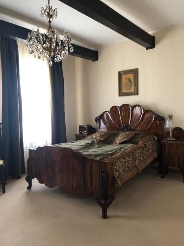 a bedroom with a large wooden bed and a chandelier at Pałac Pacółtówko in Pacółtówko