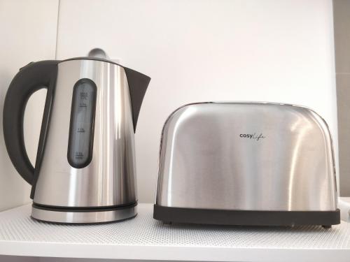 une bouilloire à thé et un grille-pain posés sur un comptoir dans l'établissement Studio Royal by Beds4Wanderlust - Place du marché avec parking privé, à Fontainebleau