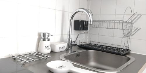 - un comptoir de cuisine avec un évier et un robinet dans l'établissement Studio Royal by Beds4Wanderlust - Place du marché avec parking privé, à Fontainebleau