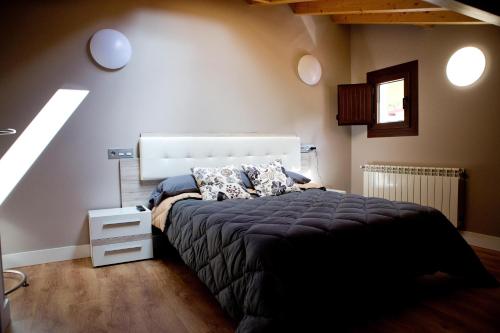 een slaapkamer met een bed en een wit nachtkastje bij Ca Roxa in Pravia