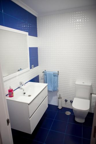 a bathroom with a white sink and a toilet at Ca Roxa in Pravia