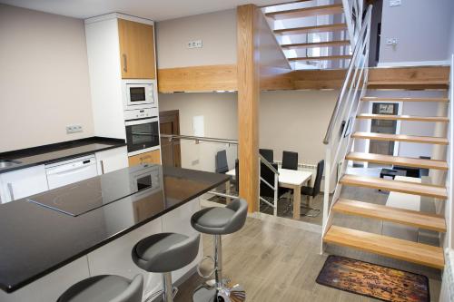 a kitchen with a counter and chairs in a room at Ca Roxa in Pravia