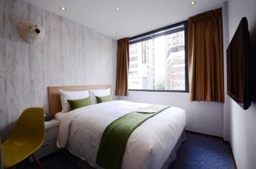 una camera d'albergo con letto e finestra di ARK Hotel - Dongmen a Taipei