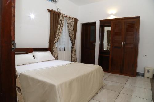 een slaapkamer met een bed en een houten deur bij Alleppey - The Beach Home in Alleppey