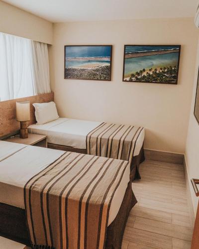 a hotel room with two beds in a room at Samoa Beach Resort in Porto De Galinhas