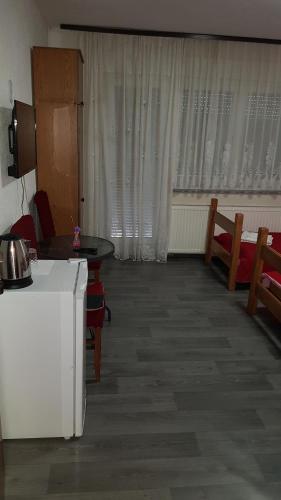 uma sala de estar com um sofá, uma mesa e cadeiras em Prenociste Sana Sanski Most em Sanski most