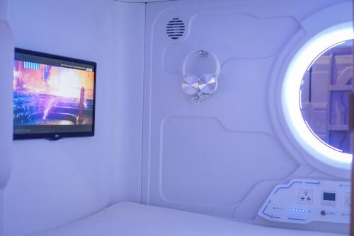 a room with a tv and a window in an airplane at The Capsule Malioboro in Yogyakarta