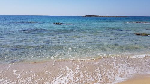 a beach with the ocean and the sand at La Spiaggetta in Torre San Giovanni Ugento