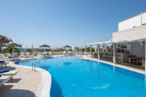 a swimming pool with a pool table and chairs at Bella Santorini in Perivolos
