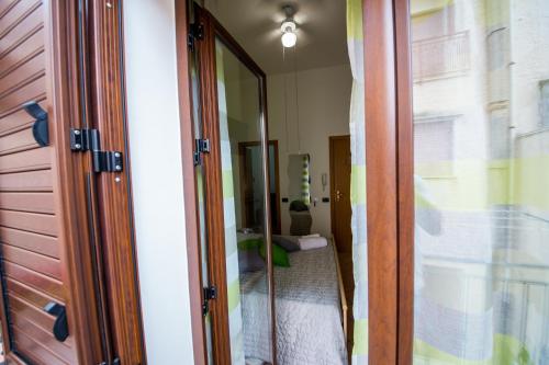 a mirror in a room with a bed at 'A Cumerdia - Casa Vacanze in Castellammare del Golfo