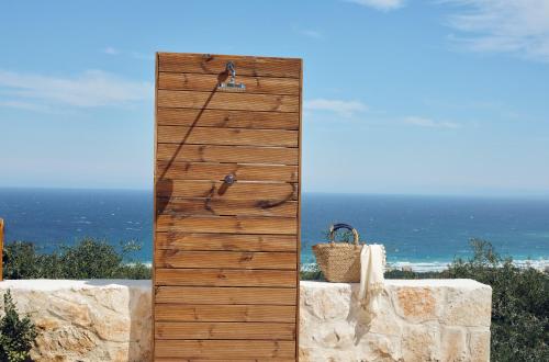 a wooden door with a basket on top of a wall at Artemis Villas - Spectacular Views & Ideal For Large Groups, By ZanteWize in Khartáta