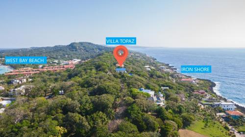 a road sign on top of a hill next to the ocean at Villa Topaz Above West Bay With 360 Degree Views! 3 Bedrooms in West Bay