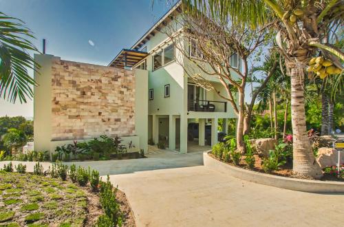 a house with palm trees in front of it at Villa Topaz Above West Bay With 360 Degree Views! 3 Bedrooms in West Bay