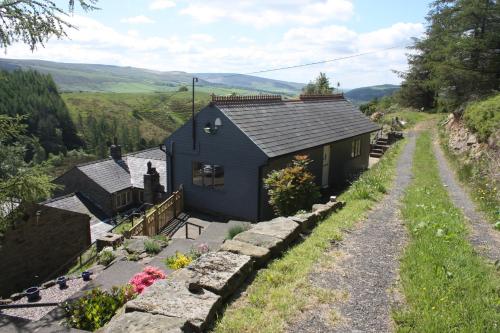 a blue house on the side of a hill at Saddleworth Holiday Cottages in Oldham